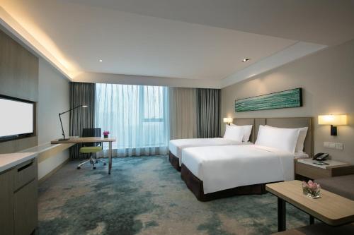 Holiday Inn Hangzhou Gongshu by IHG في هانغتشو: غرفة فندق بها سريران وتلفزيون بشاشة مسطحة
