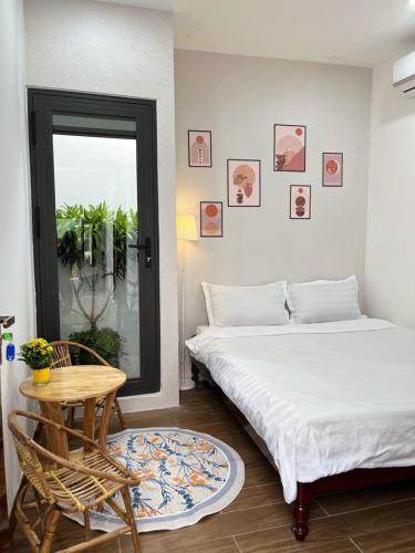 a bedroom with two beds and a table and a window at LaLa Citadel Homestay in Hue
