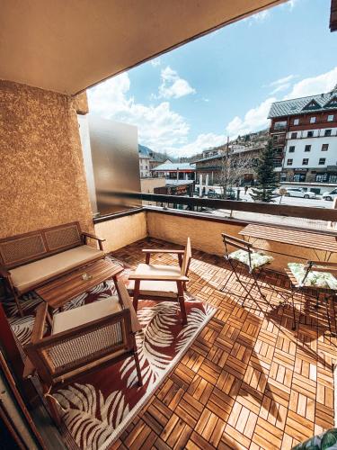 - un balcon avec une table et des bancs dans un bâtiment dans l'établissement Ô Prorel, Studio pied de pistes, à Briançon