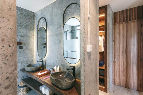 a bathroom with two sinks and two mirrors at JM Boutique Hotel in Phú Quốc