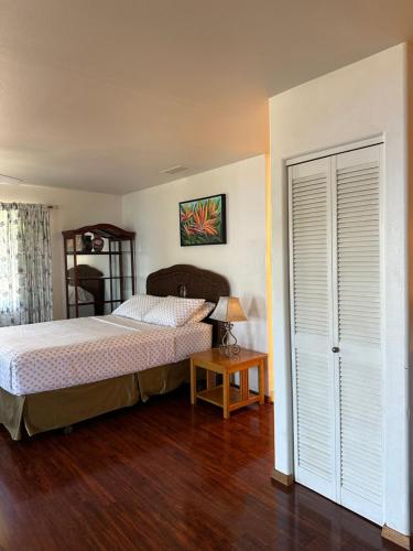 a bedroom with a bed and a table with a lamp at Kona Joe Coffee Farm in Kealakekua