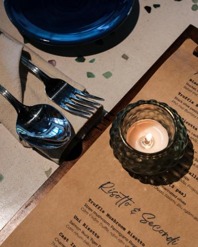 a candle sitting on top of a table with a fork at JM Boutique Hotel in Phu Quoc