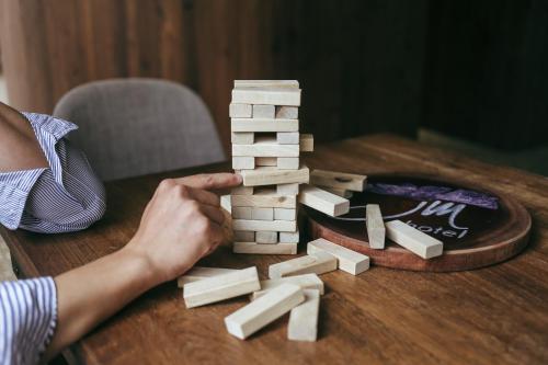a person playing with a wooden block tower on a table at JM Boutique Hotel in Phu Quoc