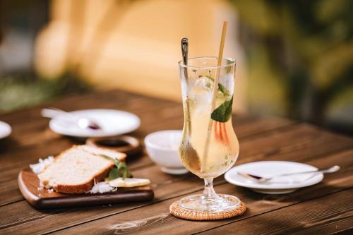 a table with a glass of champagne and a sandwich at JM Boutique Hotel in Phu Quoc