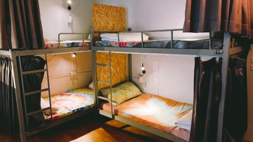 a room with three bunk beds in a room at 氮醉潛水酒吧旅宿JoScubar Diving Hostel in Xiaoliuqiu