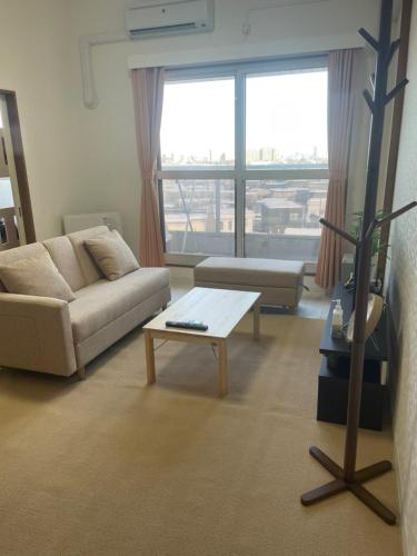 a living room with a couch and a coffee table at 500m Sta .7人PPL. FREE PORTABLE WIFI ,NEAR SUPER MARKET in Shin-kotoni