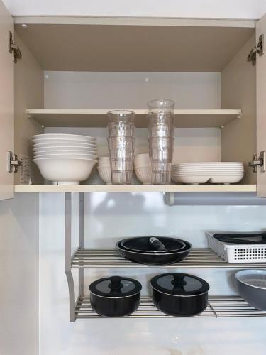 a shelf in a kitchen with plates and bowls at 500m Sta .7人PPL. FREE PORTABLE WIFI ,NEAR SUPER MARKET in Shin-kotoni