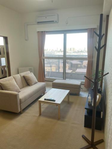 a living room with a couch and a coffee table at 500m Sta .7人PPL. FREE PORTABLE WIFI ,NEAR SUPER MARKET in Shin-kotoni