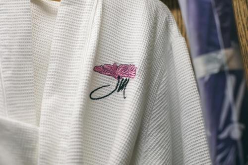 a pink flower embroidered on the side of a white shirt at JM Boutique Hotel in Phu Quoc