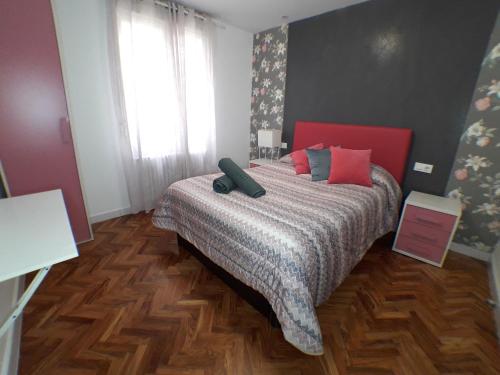 - une chambre avec un grand lit à tête rouge dans l'établissement Apartamento Turístico Miguel - Logroño, à Logroño
