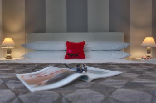 a bedroom with a bed with a book and a red pillow at Tritone Top House in Rome