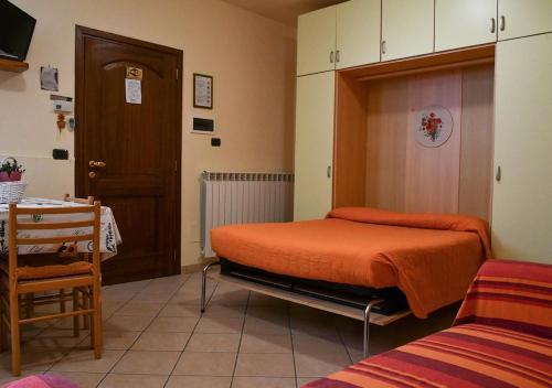 1 dormitorio con 1 cama con manta naranja en Gli Angeli Agriturismo, en Cisano sul Neva