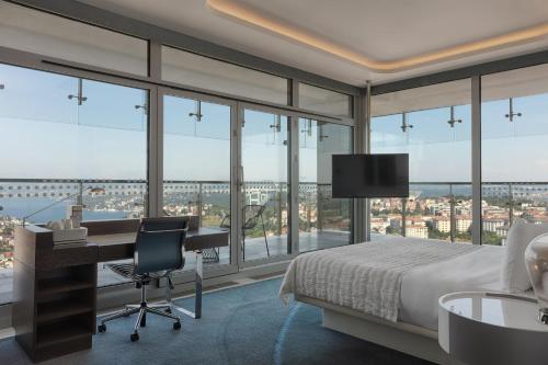 a bedroom with a bed and a desk with a desk at Le Meridien Istanbul Etiler in Istanbul