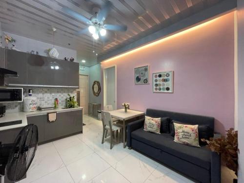 a living room with a blue couch and a kitchen at Quirino Hub Charming hotel 1 BR in Davao City