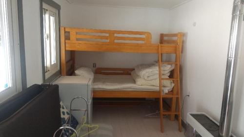 um pequeno quarto com um beliche num quarto em Ski base em Akaigawa