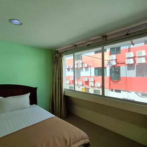 a bedroom with a bed and a large window at Best One Hotel in Malacca