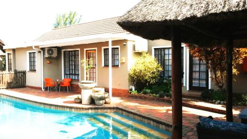 Casa con piscina y sombrilla en Old Mill Guest House en Durban