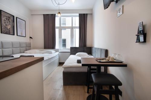 Cette chambre comprend 2 lits et une table. dans l'établissement Dream Apartments - Gdańska 72, à Łódź