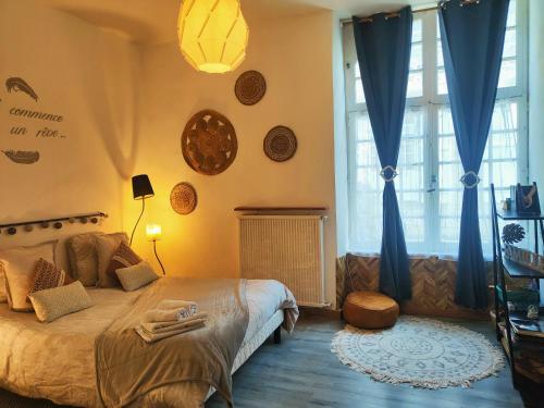 a bedroom with a large bed with blue curtains at Le Ty Rose in Dinan