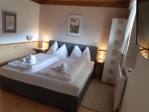 a bedroom with a large bed with white sheets and pillows at Pretty apartment in Mittersill with a view in Mittersill
