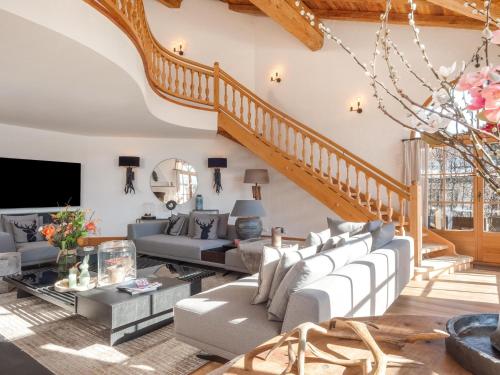 a living room with white furniture and a staircase at Exclusive Tyrolean Chalet near Ski lifts in Apfeldorf