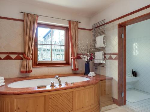 a bathroom with a tub and a window at Exclusive Tyrolean Chalet near Ski lifts in Apfeldorf