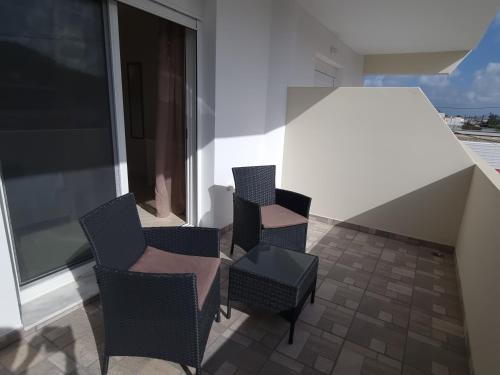two chairs and a table on a balcony at Ma Maison Bleue in Kremasti