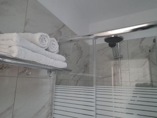 un bagno con asciugamani su scaffali nella doccia di Ma Maison Bleue a Kremasti