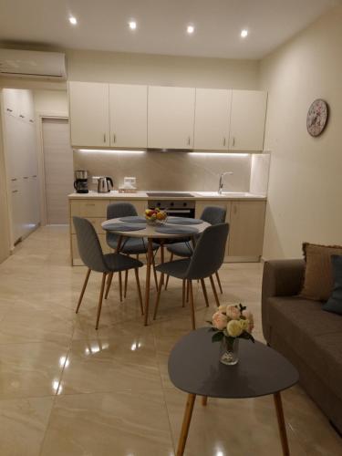 a living room with a table and chairs and a kitchen at Ma Maison Bleue in Kremasti