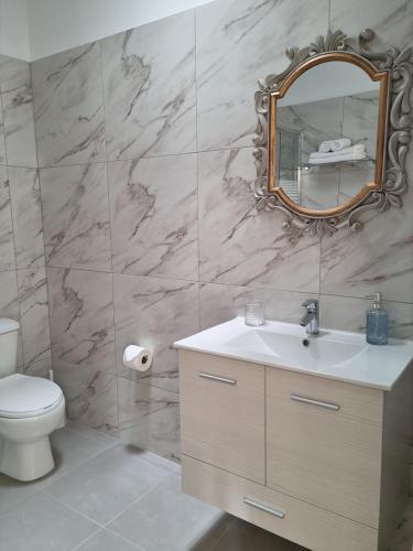 a bathroom with a toilet and a sink and a mirror at Ma Maison Bleue in Kremasti