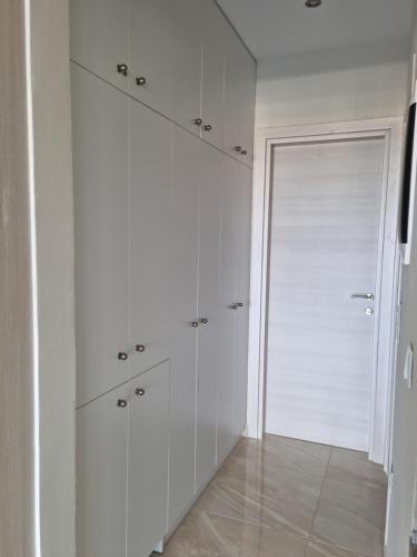 a white closet with white cabinets and a door at Ma Maison Bleue in Kremasti