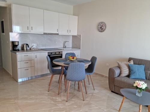 a kitchen and living room with a table and chairs at Ma Maison Bleue in Kremasti