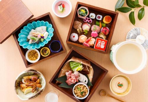 a table topped with three wooden boxes filled with food at Hatori in Kaga
