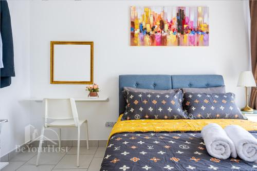 a bedroom with a blue bed with a yellow blanket at Astetica Residences Kuala Lumpur in Seri Kembangan