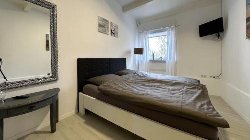 - une chambre avec un lit avec un miroir et une table dans l'établissement Huus an`t Dörpsdiek, à Krummhörn