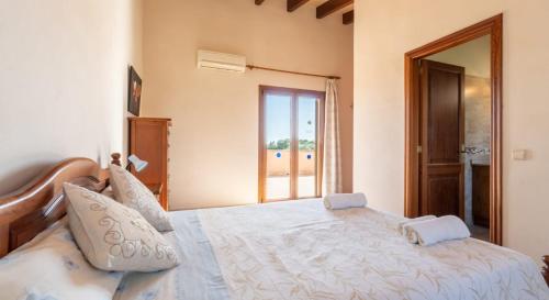 a bedroom with a large white bed with a window at Villa Rito Nou in Felanitx