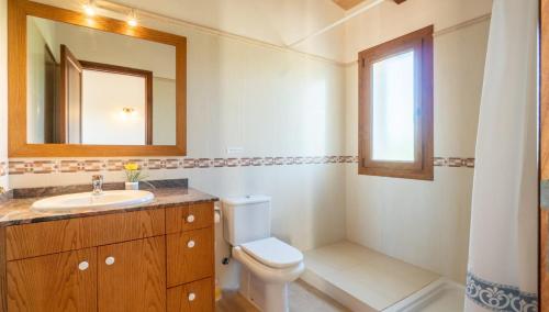 a bathroom with a toilet and a sink and a mirror at Villa Rito Nou in Felanitx
