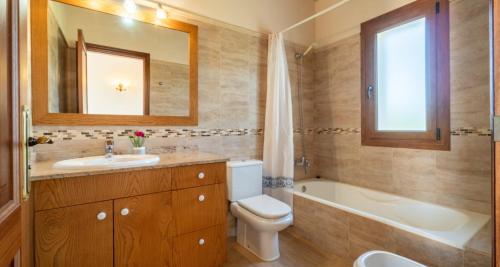een badkamer met een wastafel, een bad en een toilet bij Villa Rito Nou in Felanitx