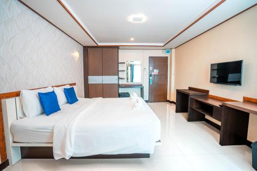 a bedroom with a bed and a desk and a television at Blue Sky Residence Airport in Ban Bang Phli Yai