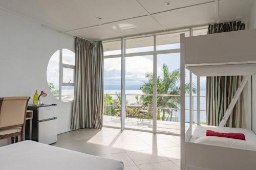 a bedroom with a bed and a view of the ocean at Exclusive Cliff House with Pool and Beach Access in Dumanjug