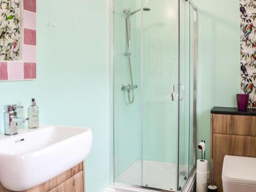 a bathroom with a glass shower and a sink at Keepers Cottage in Dumfries