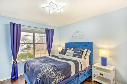 een blauwe slaapkamer met een bed en een raam bij Rowlett Escape with Fire Pit and Lake Views! in Rowlett