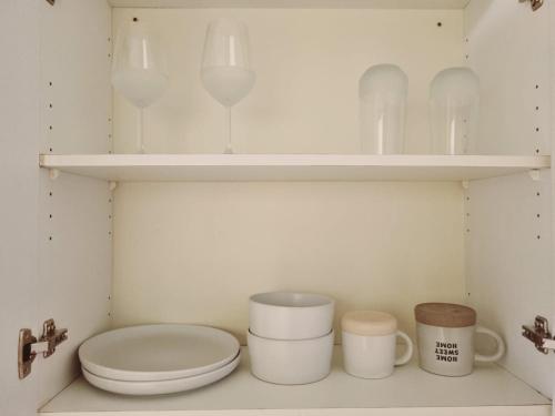 a bathroom with a toilet and some cups and shelves at Hatfield Grosvenor Private Apartments in Pretoria