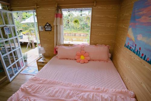 a bedroom with a pink bed with a flower on it at HomeTa Homestay in Bao Loc