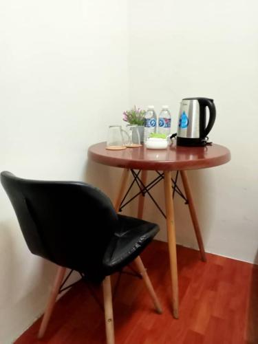 a table with a chair and a coffee maker on it at Aeropod Hostel Economy Twin Room in Kapayan