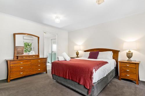 a bedroom with a bed and a large mirror at Kensington Escape - Balcony, BBQ and Parking in Melbourne