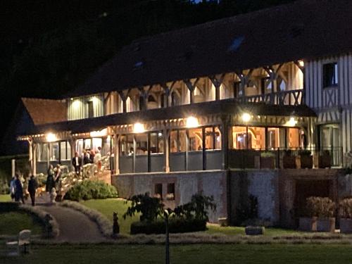 a large building with people standing outside at night at Holiday home Le clos du phare in Saint-Samson-de-la-Roque