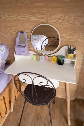 a white table with a mirror and a chair at HomeTa Homestay in Bao Loc