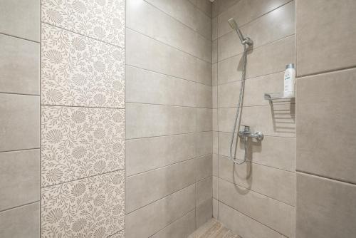 a bathroom with a shower with a tile wall at Athenian Niche in Plaka Villa by Athenian Homes in Athens