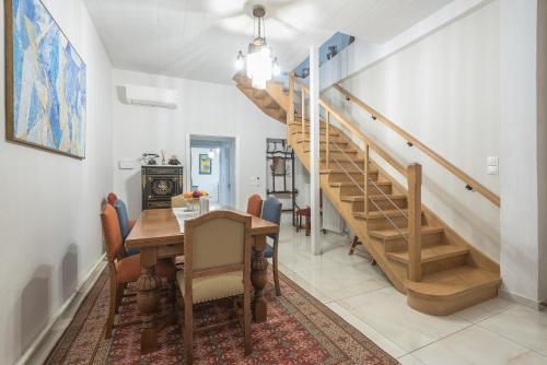 a dining room with a table and a staircase at Athenian Niche in Plaka Villa by Athenian Homes in Athens